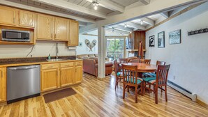 A kitchen with wooden cabinets, a dishwasher, and a microwave. There is a dining area with a wooden table and chairs. - Mtn-View Condo w/ Community Perks in Silverthorne (Silverthorne)