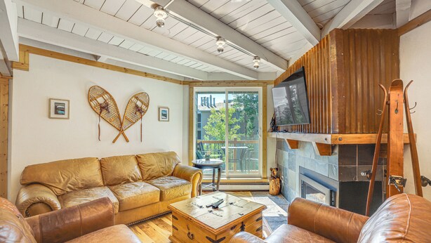 A cozy living room with a leather sofa, a wooden coffee table, and a fireplace. - Mtn-View Condo w/ Community Perks in Silverthorne (Silverthorne)