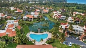 A residential area with houses, a swimming pool, and a road. - Quaint villa Beach access Elina (Sabana)