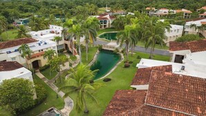 Un quartier résidentiel avec des maisons, une piscine et des palmiers.