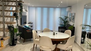 A modern dining area with a round table and chairs, a staircase, and potted plants. - 3BR Villa Mira  short stroll from the Beach & Pool (Dorado)