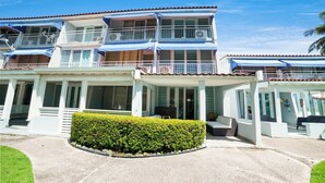 A two-story building with balconies, a covered entrance, and a well-maintained hedge. - 3BR Villa Mira  short stroll from the Beach & Pool (Dorado)