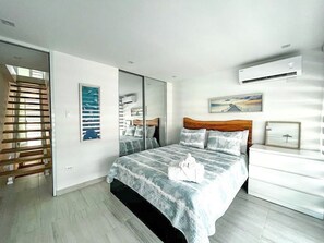 Een moderne slaapkamer met een groot bed, een houten hoofdbord, een nachtkastje en een wandairconditioner.
