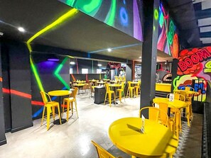 A vibrant indoor space with yellow tables and chairs, geometric wall designs, and a colorful mural. - 3BR Villa Mira  short stroll from the Beach & Pool (Dorado)