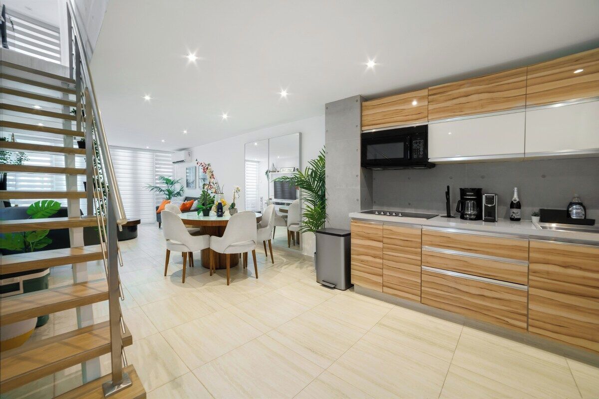 Een moderne keuken met houten kastjes, een ingebouwde magnetron en een koffiezetapparaat.