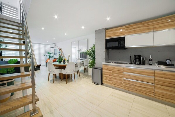 A modern kitchen with wooden cabinets, a built-in microwave, and a coffee maker.