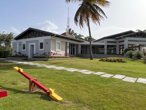Un bâtiment moderne doté d’un espace extérieur couvert et d’une balançoire en premier plan.