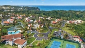 A resort with multiple buildings, a tennis court, and a view of the ocean. - Giovanni Beachfront community w/pools (Sabana)