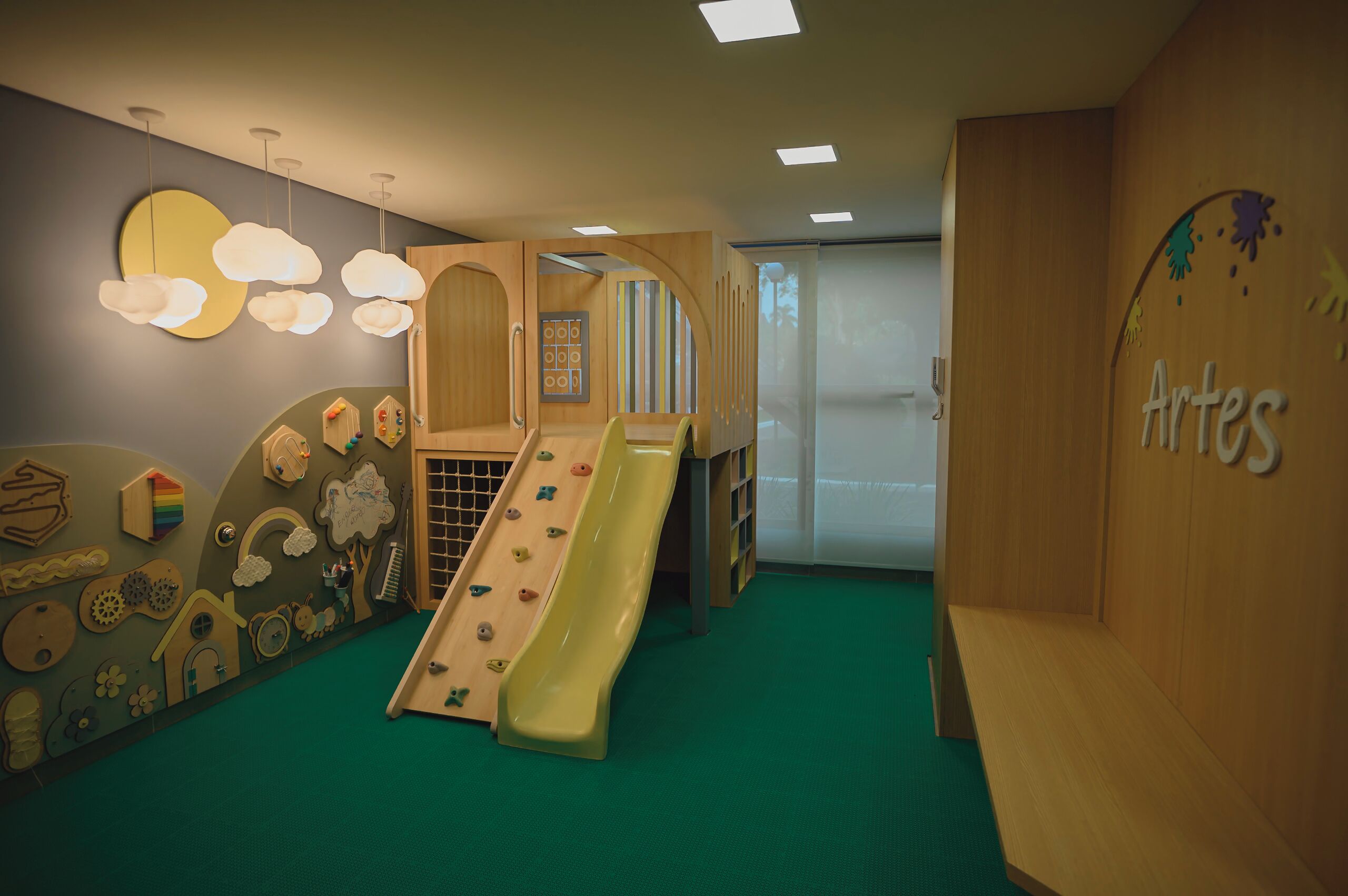 A children's play area with a slide, climbing wall, and various play structures.