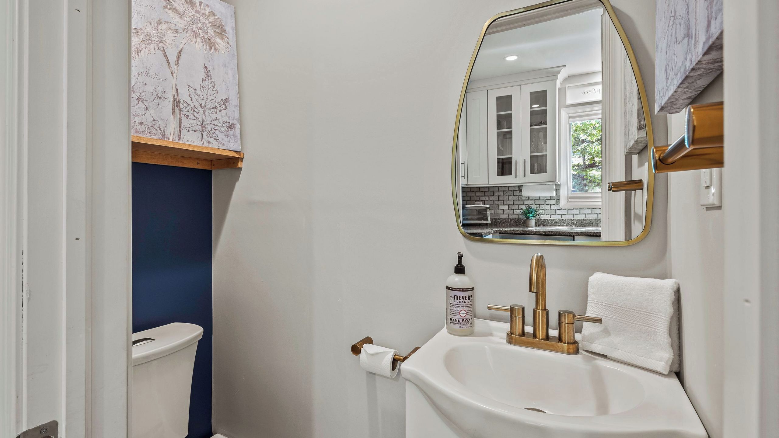 Une salle de bain avec des toilettes, un lavabo et un miroir.