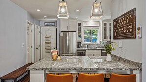 A modern kitchen with granite countertops, stainless steel appliances, and pendant lighting. - Slopeside Escape by Avantstay Walk to Ski Lifts Arcade Games + Shuffleboard (Tannersville)