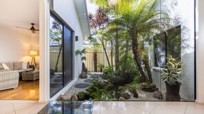 A modern living room with a glass coffee table, a sofa, and a lamp. - The Atrium by Experience Jervis Bay (Saint Georges Basin)