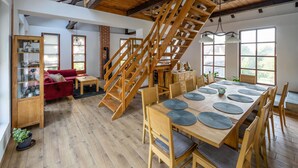 A spacious dining area with a wooden staircase leading to an upper level.