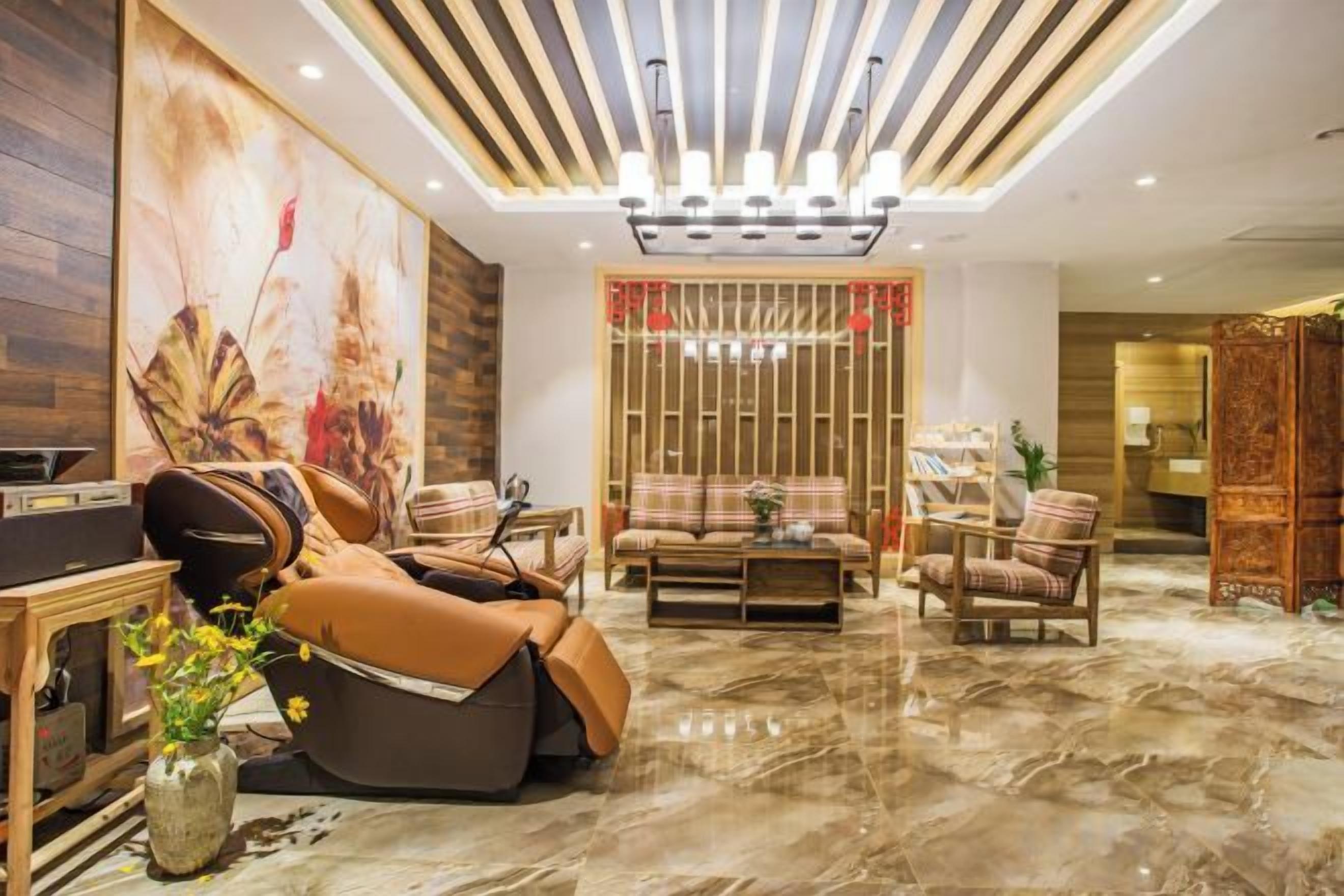 A modern living room with a sofa, armchairs, a coffee table, and a decorative wall.