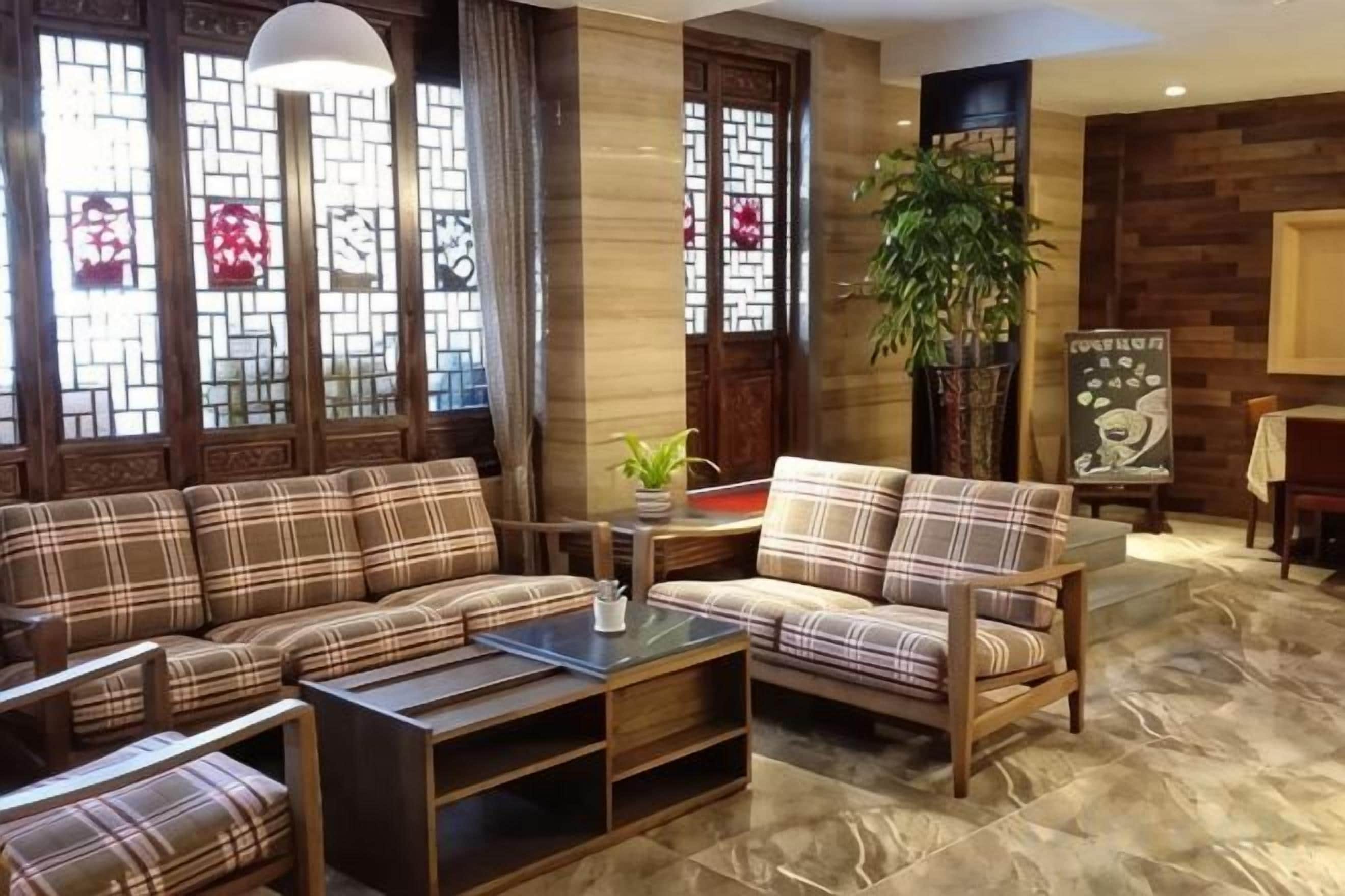 A modern living room with a sectional sofa, a coffee table, and a potted plant.