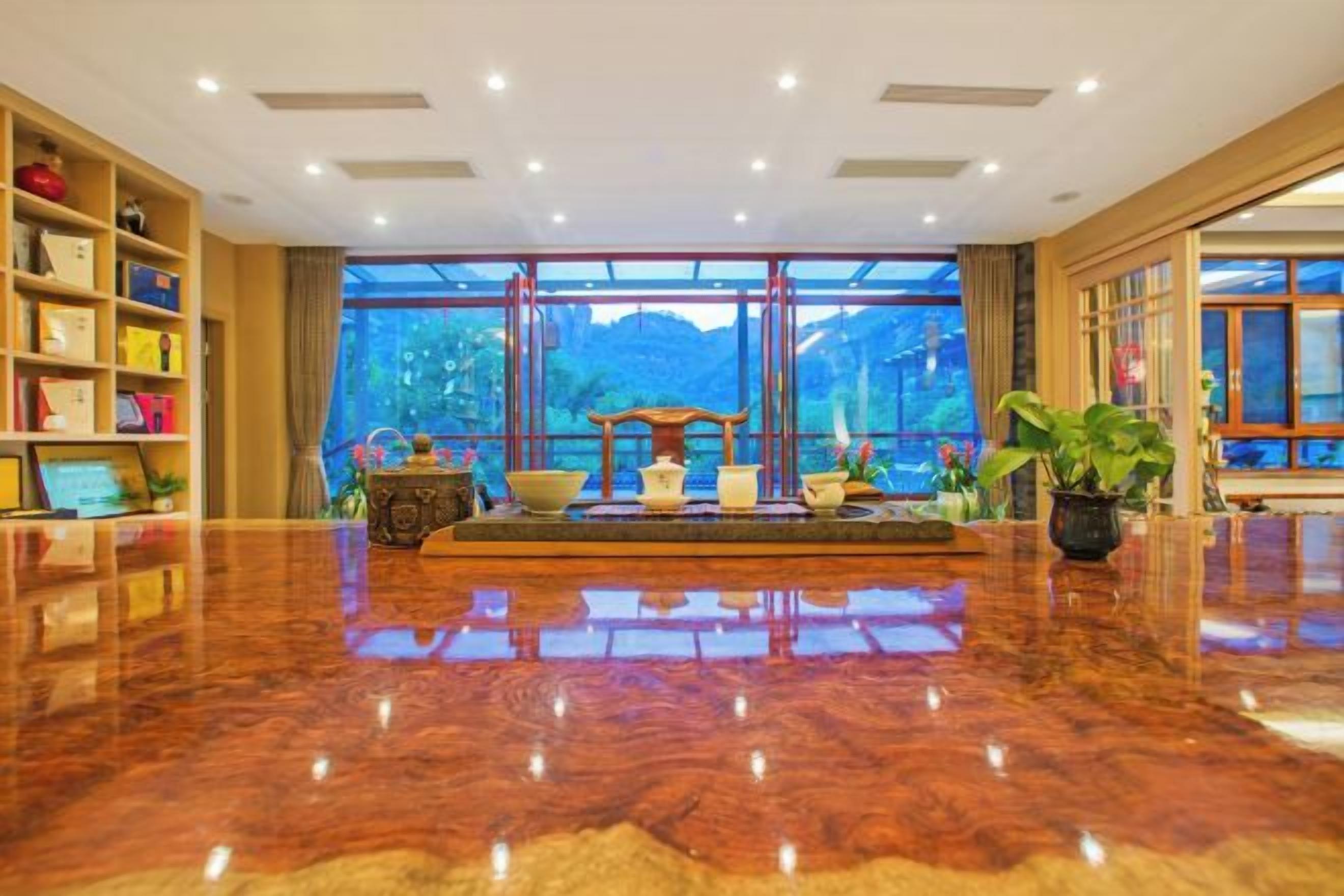 Un vestíbulo espacioso con piso de mármol pulido, una recepción y ventanas amplias con vistas al exterior.