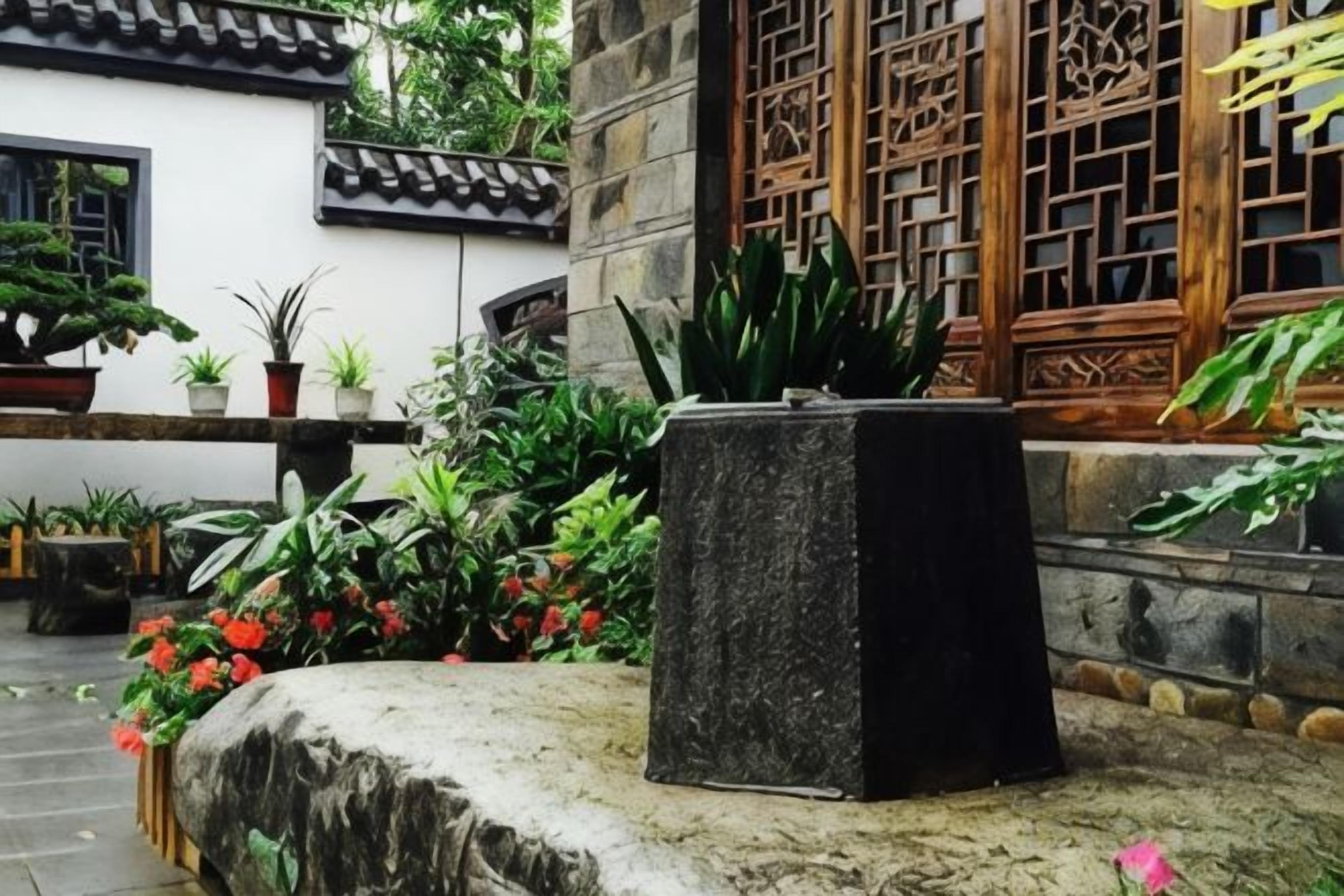 Un patio con plantas en macetas y un banco de piedra.