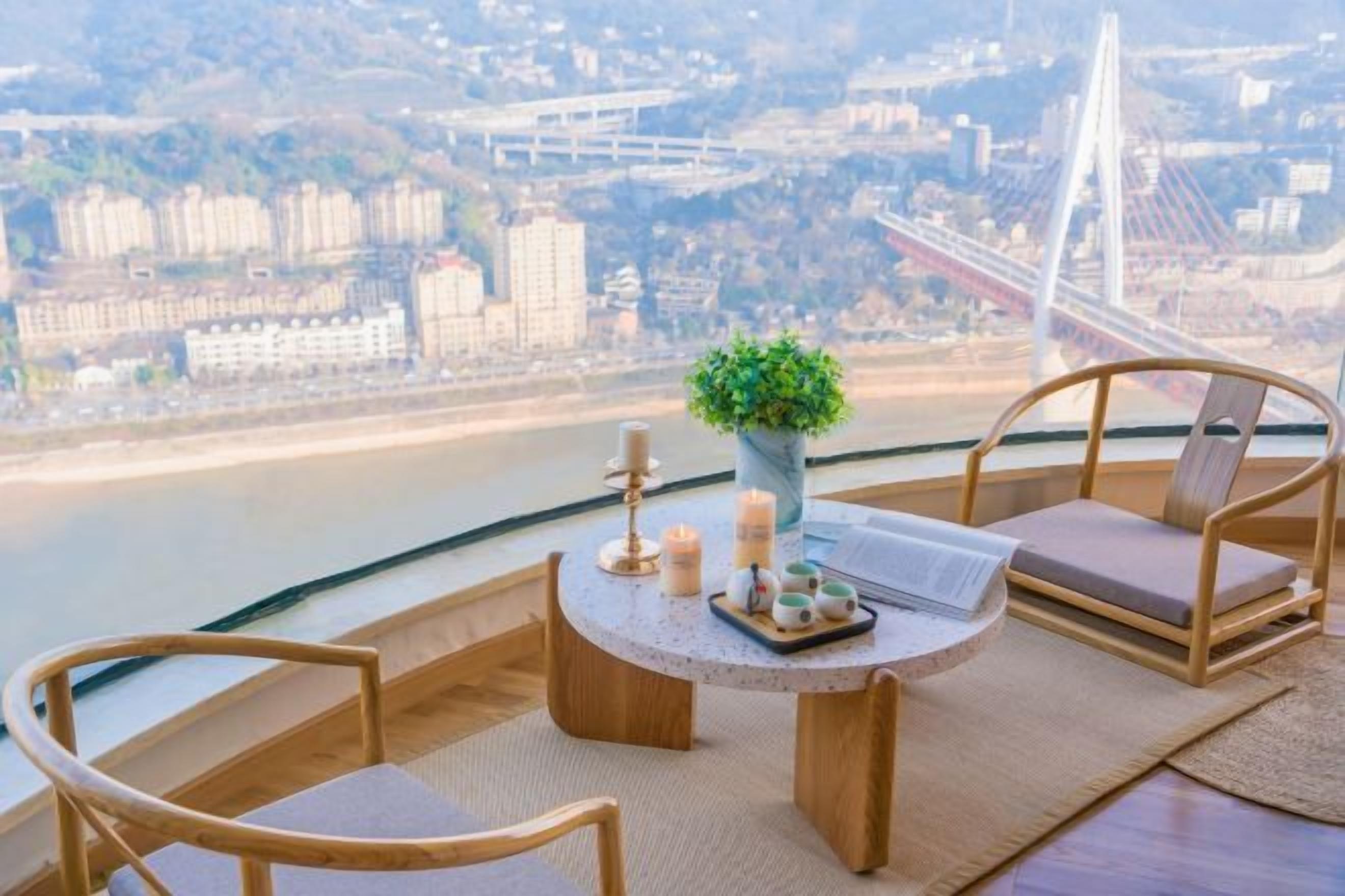 Un balcon avec une table, des chaises et une vue sur le paysage urbain, notamment un pont.