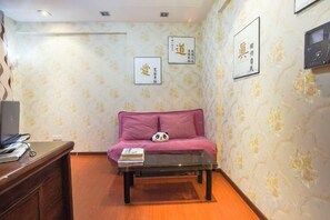 A room with a sofa, a coffee table, and a wall with framed artwork. - Meitu Apartment Hotel (Chongqing Jiefangbei Chaotianmen Branch) (Chongqing)