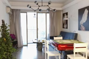 Un saló amb un sofà, una taula de menjador i cadires. Hi ha una porta corredissa de vidre que dona a un espai exterior.