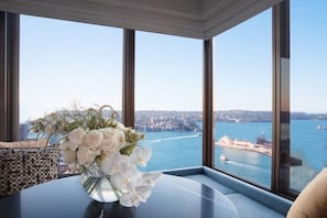 A room with a large window offering a view of a cityscape and a body of water.