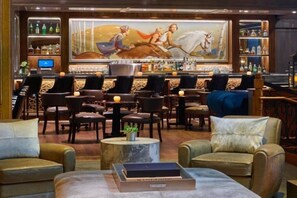 A bar area with leather chairs, a bar counter, and a large painting on the wall. - St Regis Residence Club 3 Bedroom - Heart of Downtown Aspen! (Aspen)