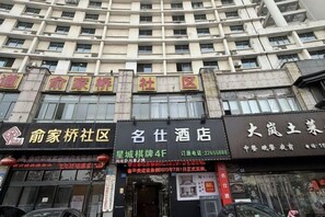 A building with multiple storefronts, including a hotel and a restaurant. - Mingshi Hotel Yuyao Wanda Plaza Branch (Yuyao)