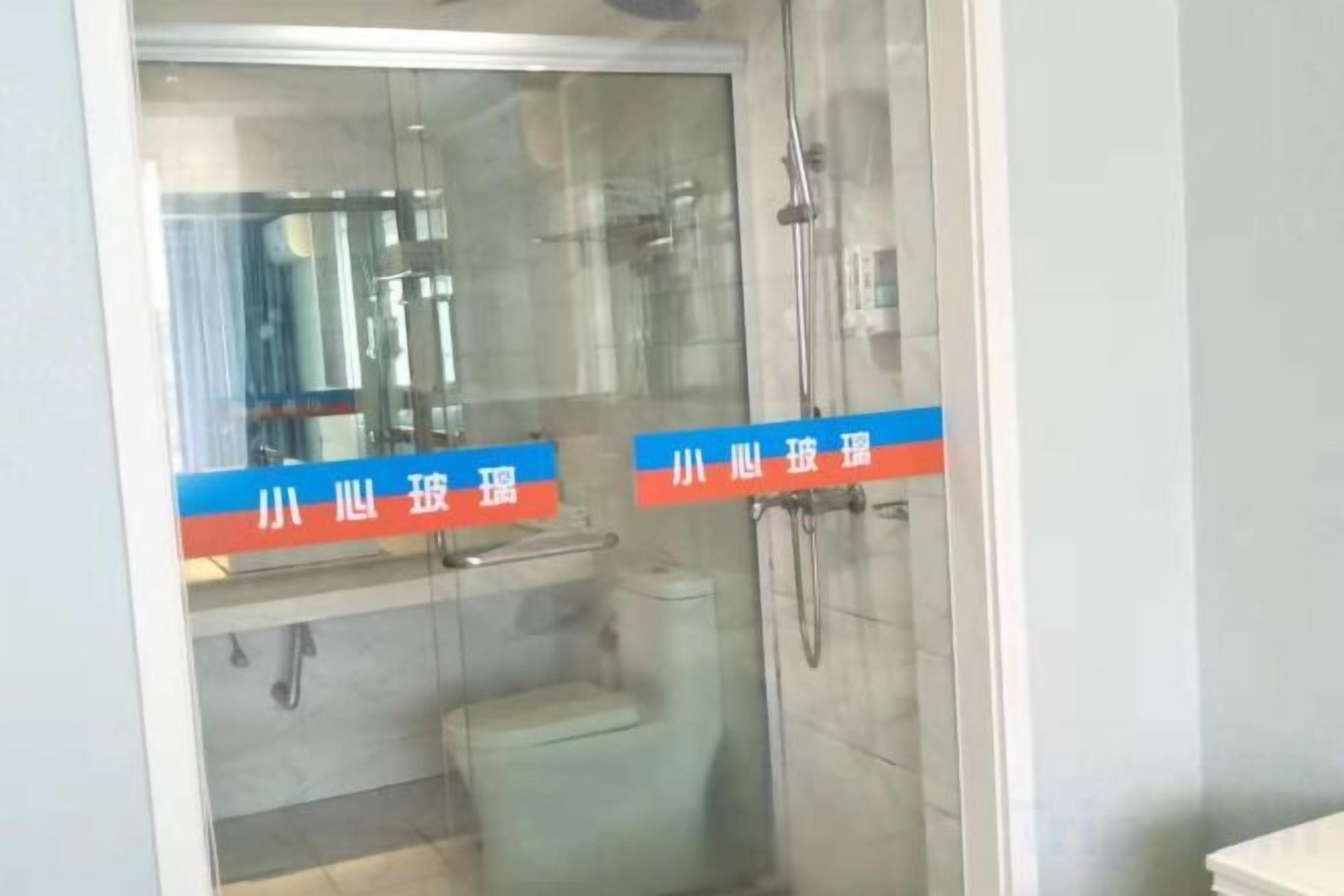 Un baño con mampara de vidrio, inodoro y zona de ducha.