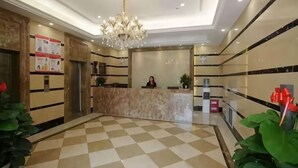 A hotel lobby with a checkered floor, a reception desk, a chandelier, and a receptionist. - Mingshi Hotel Yuyao Wanda Plaza Branch (Yuyao)