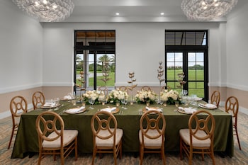 A modern room with a sofa, a round coffee table, a mirror, and a wall art piece. at The Belgrove Resort & Spa, West Palm Beach, Autograph Collection