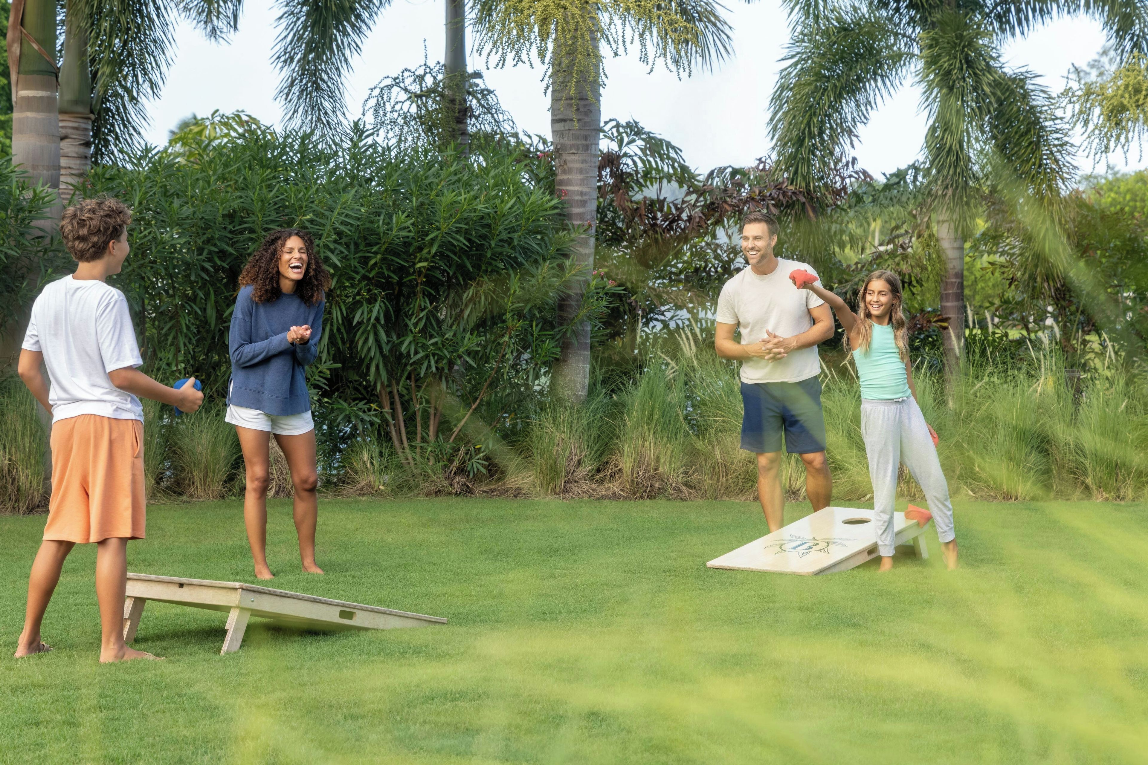 A group of people playing a game outdoors with a flat surface and a target.