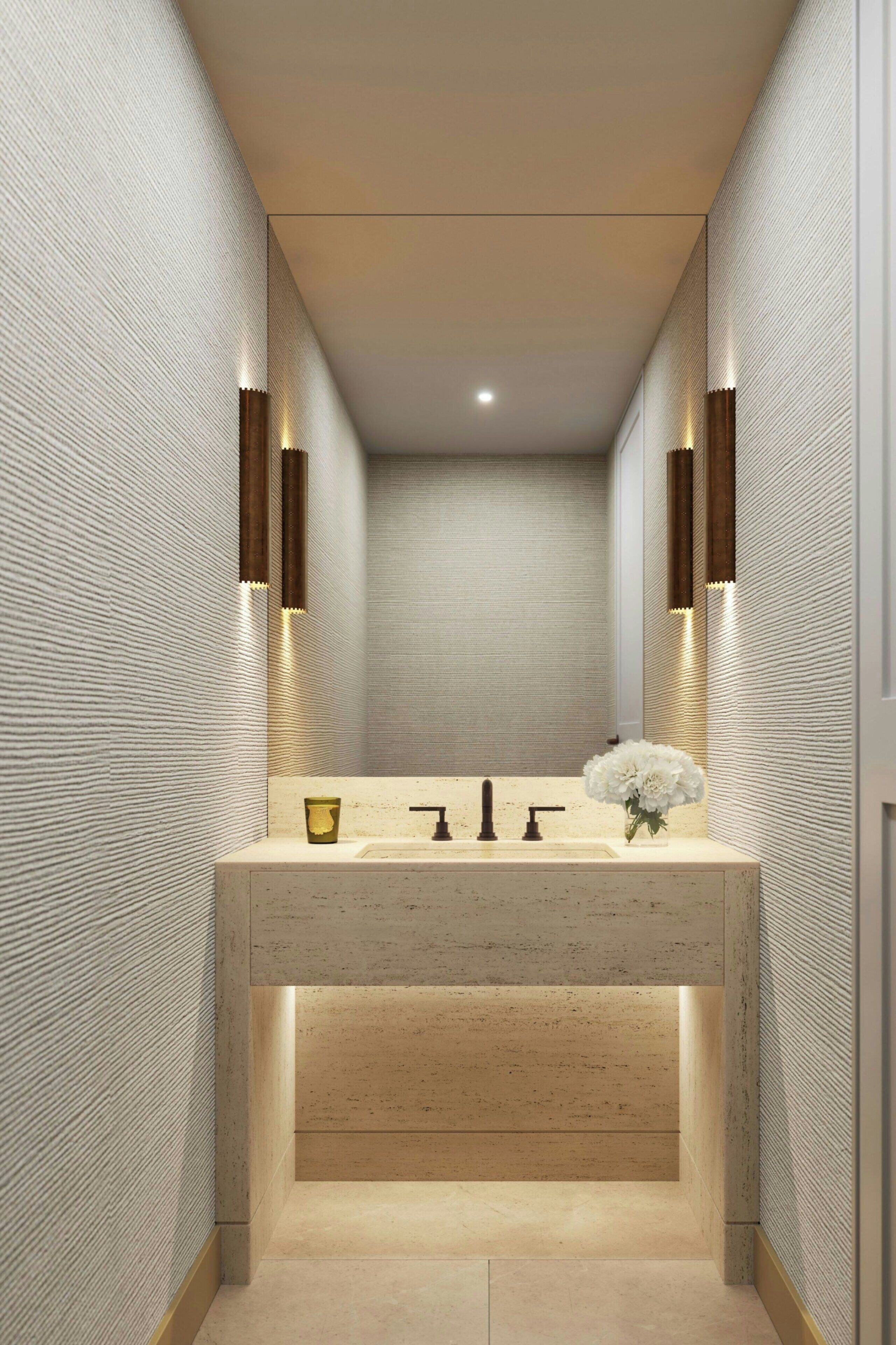 A modern bathroom with a central sink, two wall-mounted lights, and a mirror.
