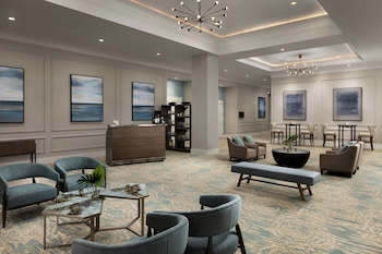 A spacious living room with a fireplace, comfortable seating, and artwork on the walls. at The Belgrove Resort & Spa, West Palm Beach, Autograph Collection