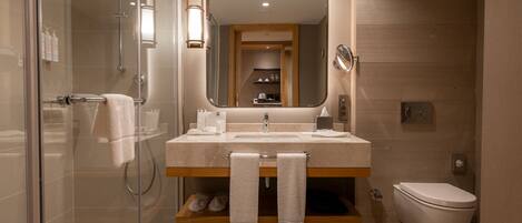 Une salle de bain moderne avec une douche à parois de verre, un meuble-lavabo avec un miroir et des toilettes.