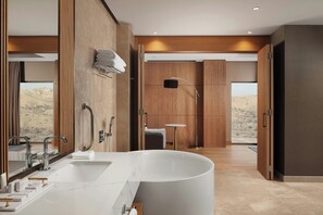 A modern bathroom with a large bathtub, dual sinks, and a mirror. - Cappadocia Marriott Hotel (Nevsehir)