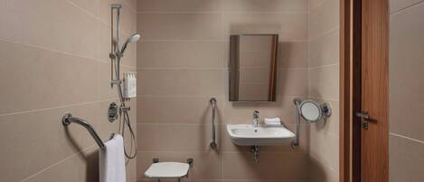 Un baño pequeño y moderno con ducha, lavamanos e inodoro.