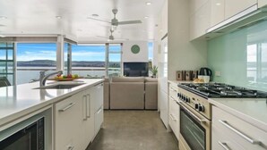 A modern kitchen with a large island, a built-in oven, and a view of the outdoors.