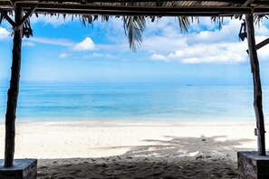 A beach view with a wooden structure and a clear sky. - Isara Lanta Beach Resort (Koh Lanta)