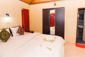 A bedroom with a bed, pillows, a wardrobe, and a bathroom visible through an open door. - Isara Lanta Beach Resort (Koh Lanta)