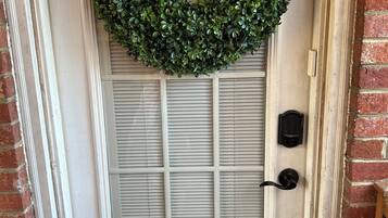 A door with a green wreath, a mailbox, and a doorbell.