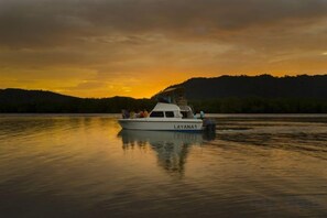 A boat named 'LAYANA1' on calm water with a sunset in the background. - Layana Resort & Spa (Koh Lanta)