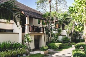 A two-story building with a balcony, surrounded by lush greenery and a pathway. - Layana Resort & Spa (Koh Lanta)