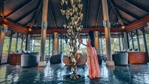 A covered outdoor area with a central sculpture, seating, and a view of the outdoors. - Layana Resort & Spa (Koh Lanta)