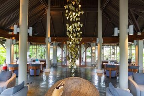 A spacious lobby with a high ceiling, large windows, and a central decorative element. - Layana Resort & Spa (Koh Lanta)