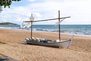 Un bateau à voile sur une plage de sable.