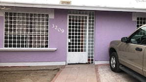 A house with a purple exterior, a white door, and a garage door.
