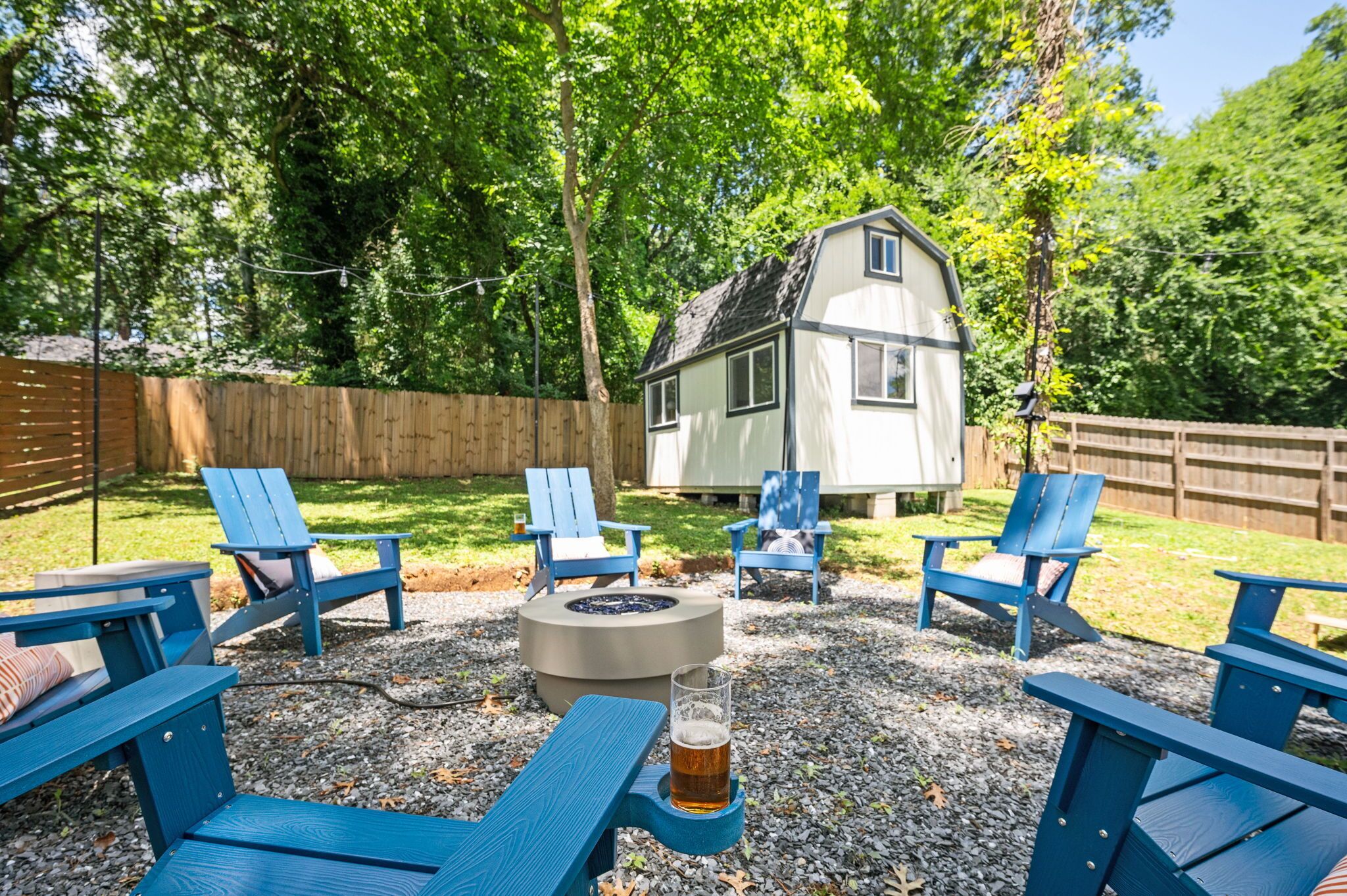 Un jardin avec un foyer, un espace salon extérieur et une petite maison.