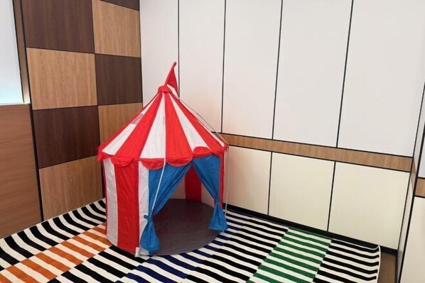 A room with a striped floor, a small tent-like structure, and a wooden panel wall. - Yatai Longda Hotel (Changchun)