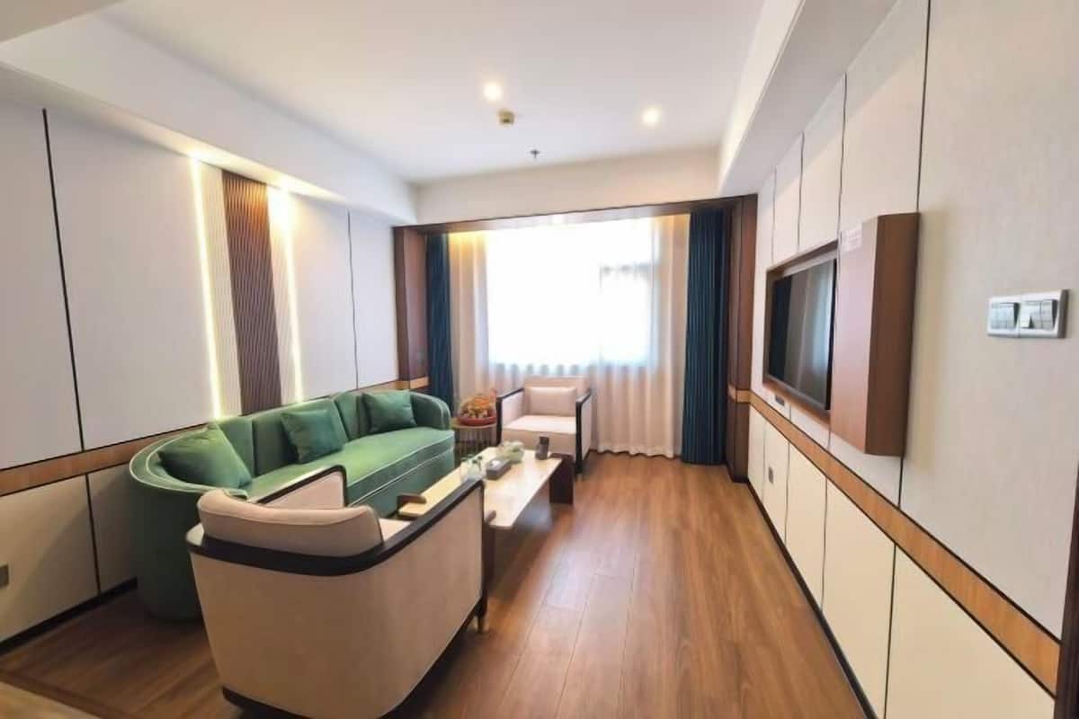 Una sala de estar moderna con un sofá, una mesa de centro y un televisor de pantalla plana montado en la pared.