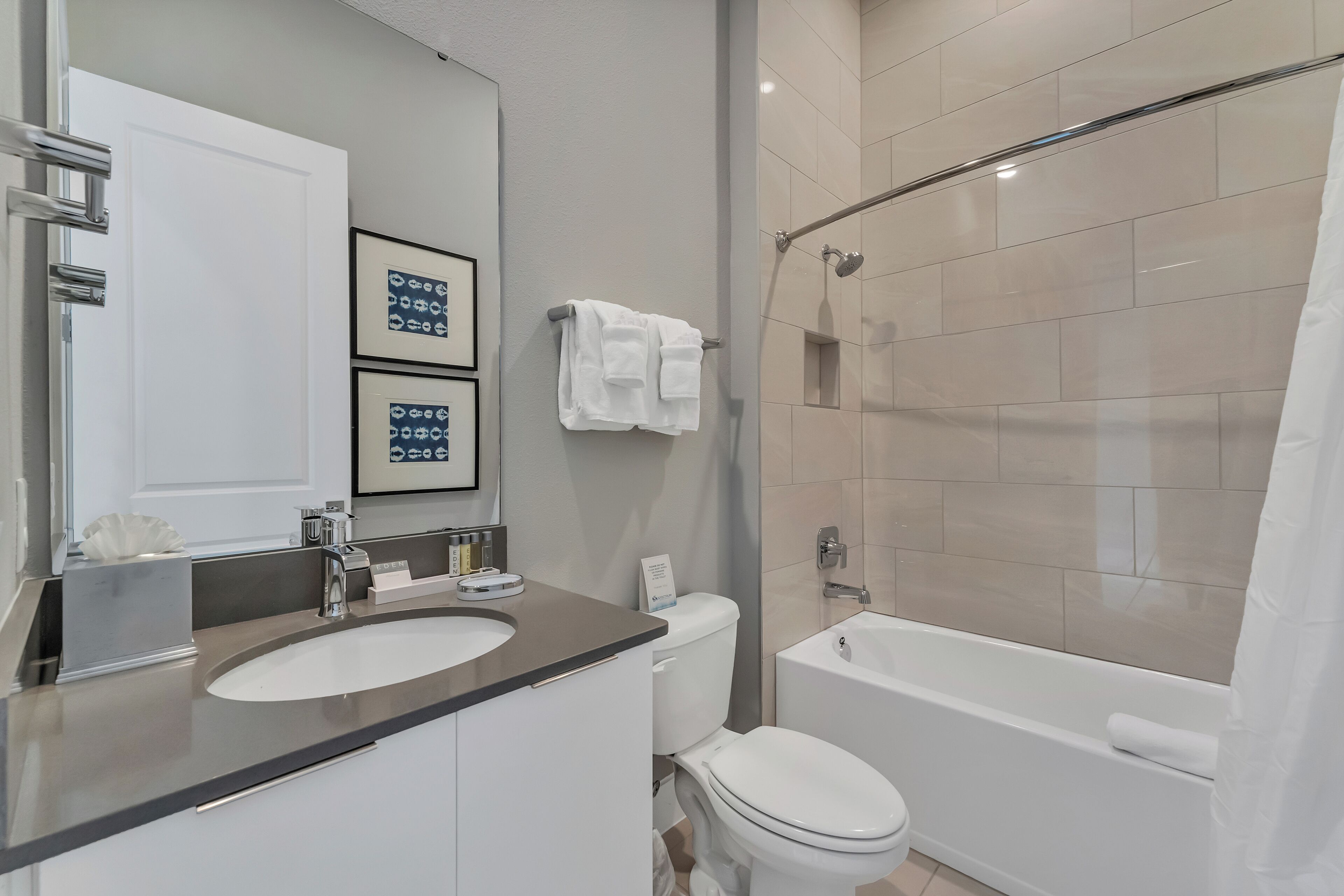 Une salle de bain moderne avec un lavabo, des toilettes et une baignoire.